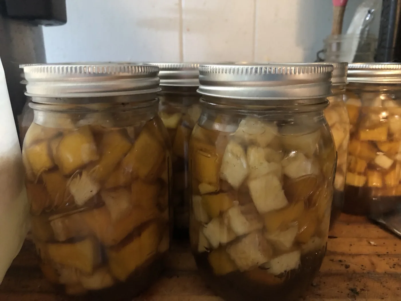 Glass jars filled with cubed yellow and pale vegetables.